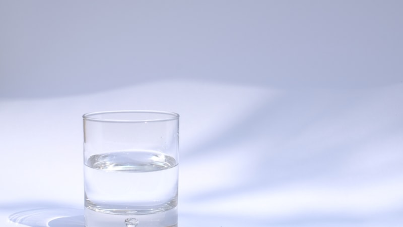 Verre d'eau pure sur fond neutre